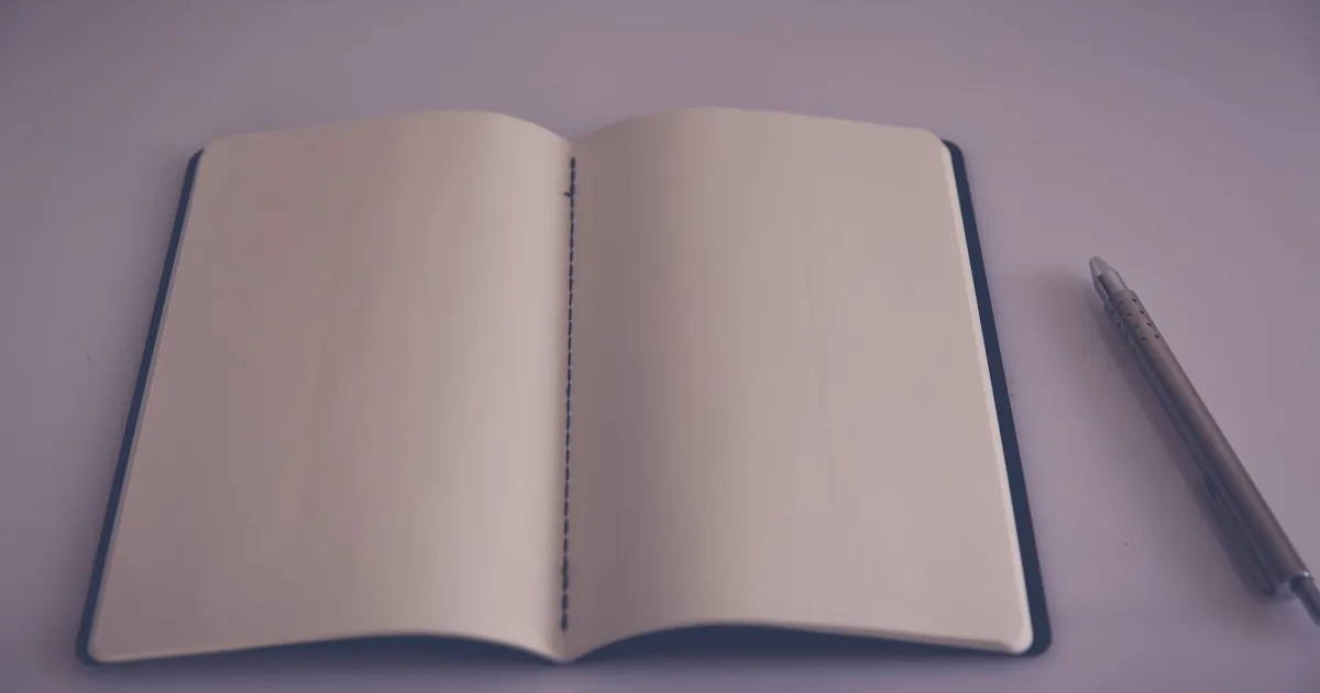 Otwarty notes z długopisem, symbol kreatywności przypisywanej trójce