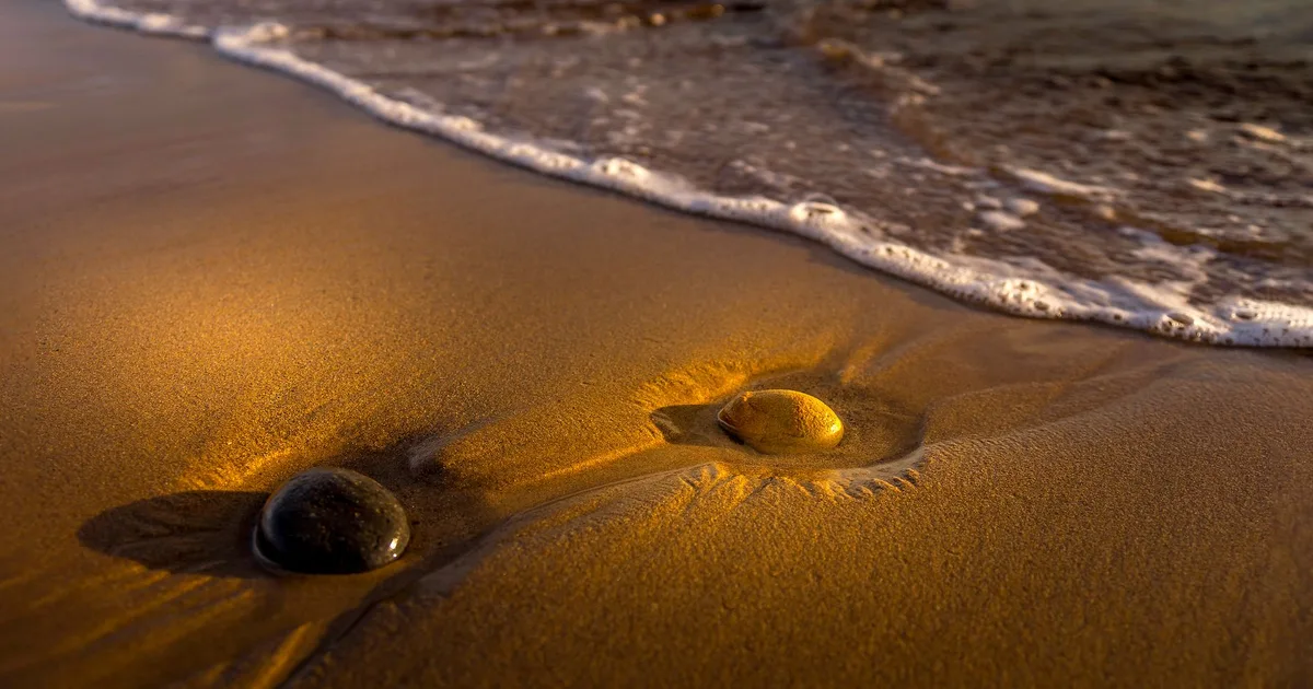 Dwa kamienie na plaży, symbol równowagi przypisywanej dwójce